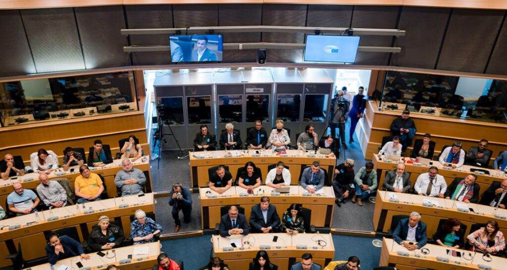 People gathered in a conference room with interpreters.